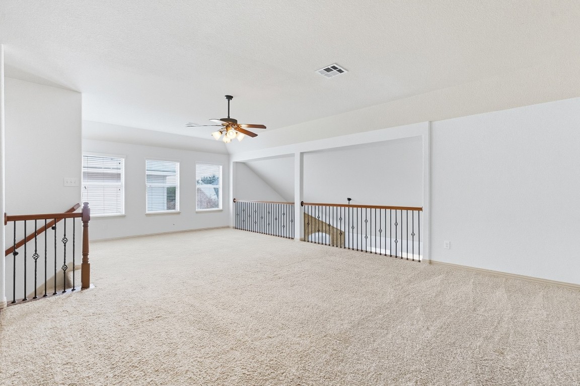 2409 Pauma Valley Way Pflugerville, TX 78660 - Photo 31 of 37 Spare room with carpet, vaulted ceiling, and a ceiling fan