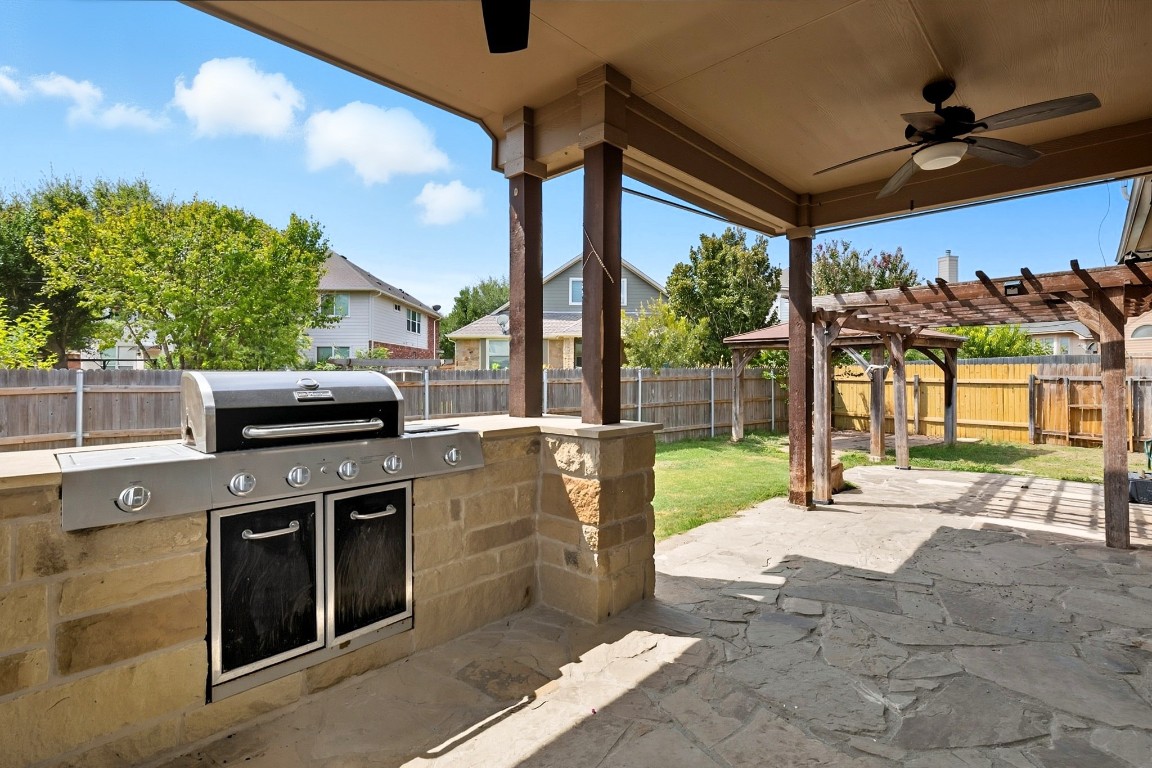 2409 Pauma Valley Way Pflugerville, TX 78660 - Photo 33 of 37 Fenced backyard featuring ceiling fan, area for grilling, a pergola, and a patio