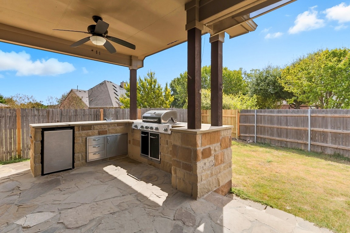 2409 Pauma Valley Way Pflugerville, TX 78660 - Photo 34 of 37 Fenced backyard featuring exterior kitchen, a patio area, and a ceiling fan