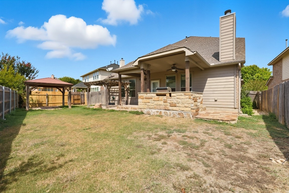 2409 Pauma Valley Way Pflugerville, TX 78660 - Photo 37 of 37 Back of house featuring a patio area, a fenced backyard, a chimney, ceiling fan, and a gazebo