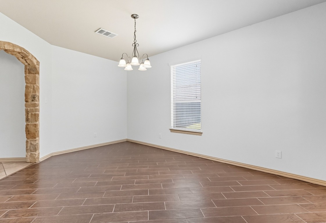 2409 Pauma Valley Way Pflugerville, TX 78660 - Photo 5 of 37 Spare room featuring wood tiled floors and a chandelier
