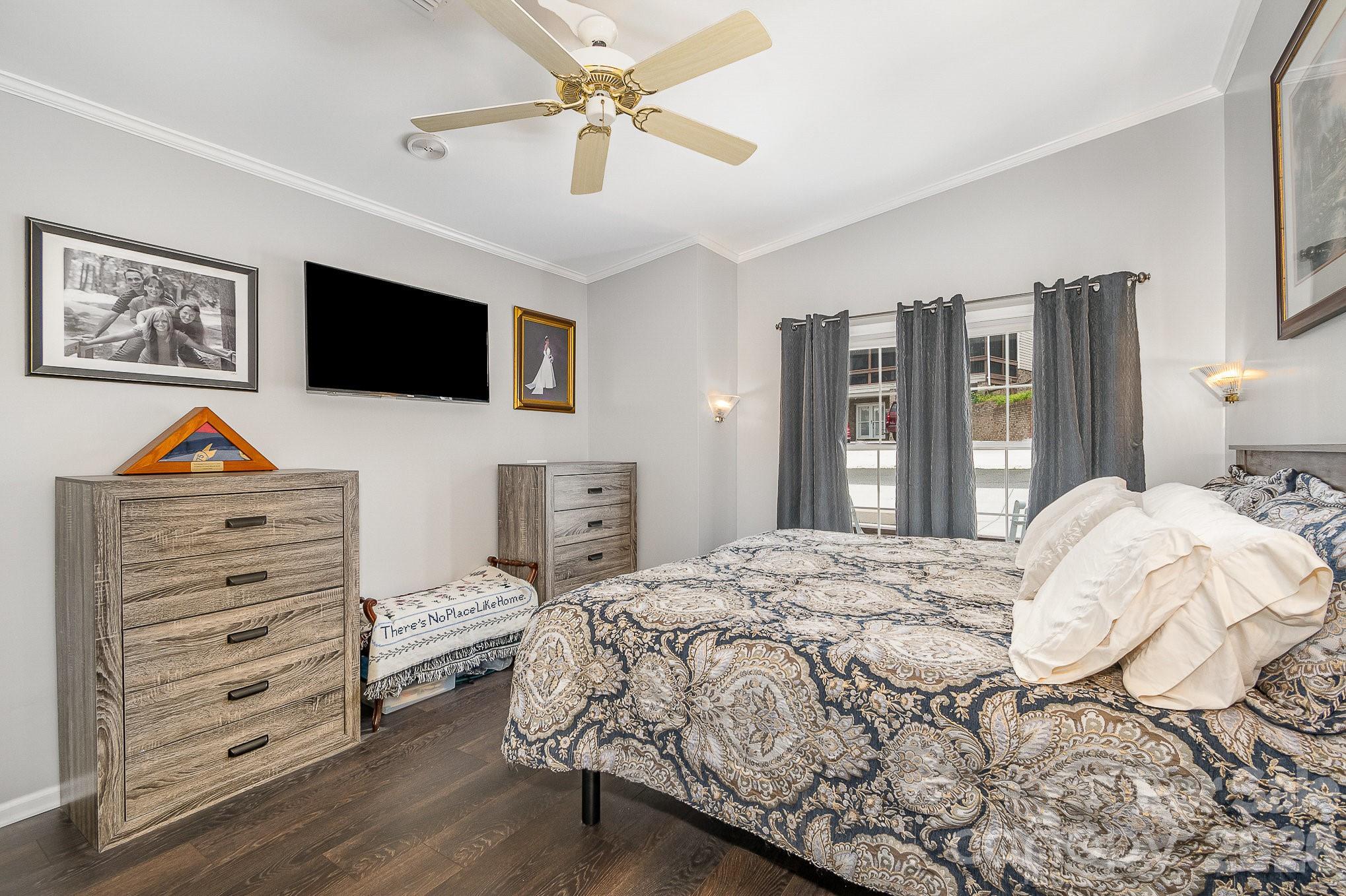 141 Badin Lake Road New London, NC 28127 - Photo 12 of 47 a bedroom with a bed a dresser and a flat screen tv