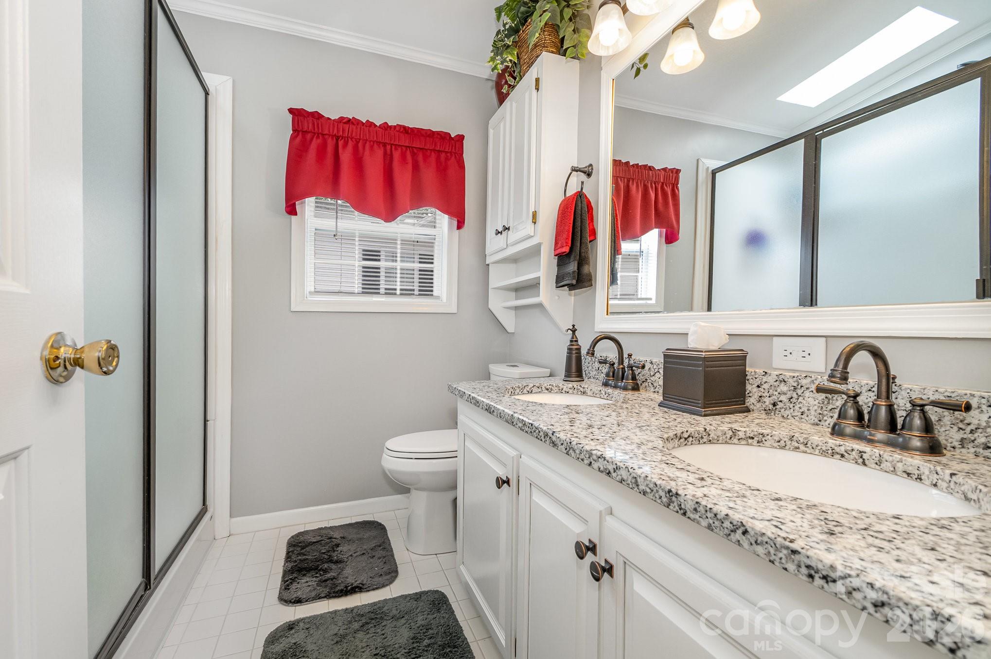 141 Badin Lake Road New London, NC 28127 - Photo 16 of 47 a bathroom with a granite countertop sink mirror vanity and toilet