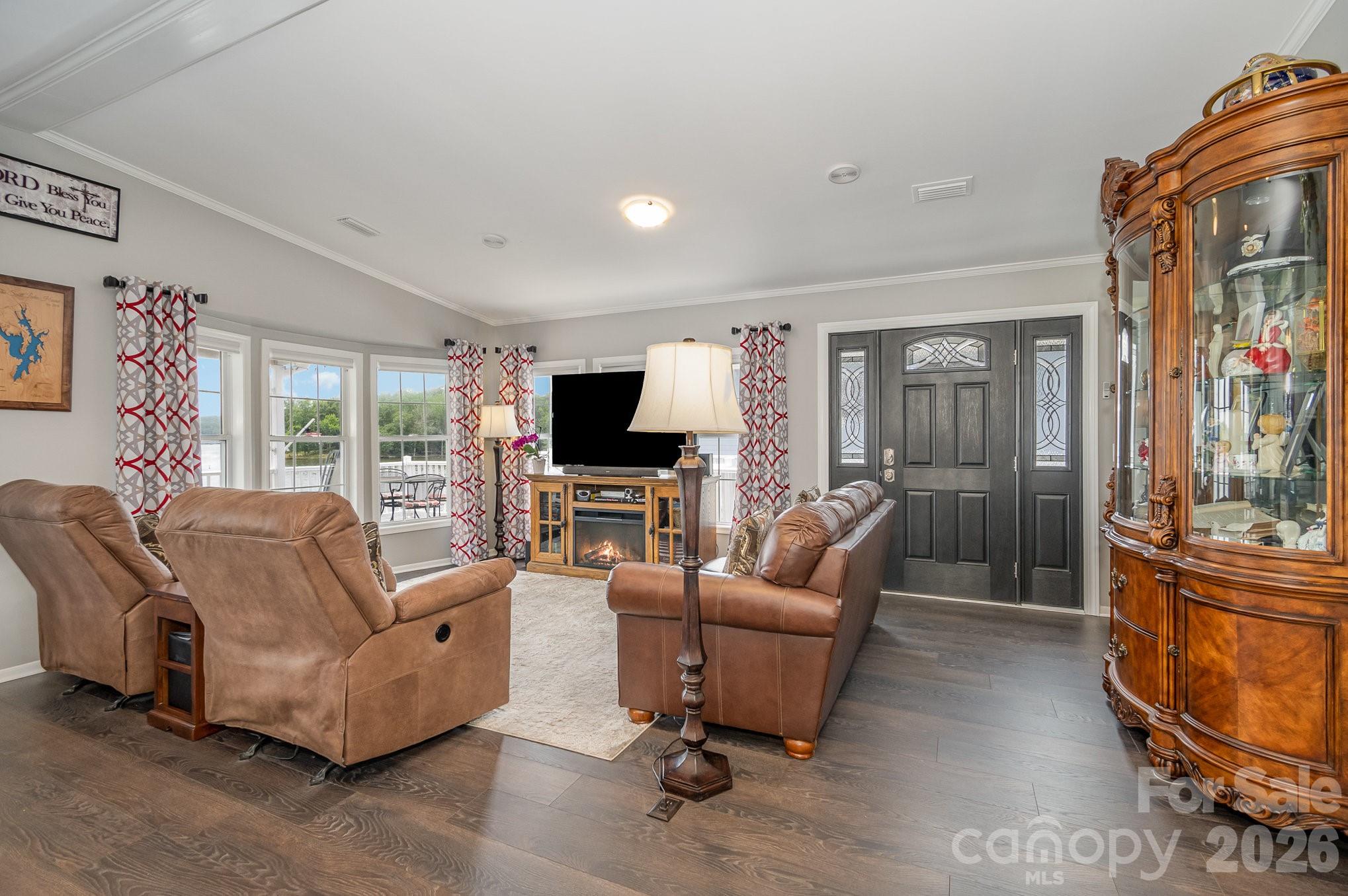 141 Badin Lake Road New London, NC 28127 - Photo 5 of 47 a living room with furniture a flat screen tv and a floor to ceiling window