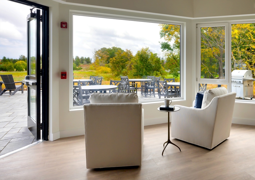 130 Chief Justice Cushing Highway, Unit 213 Scituate, MA 02066 - Photo 16 of 40 a living room with furniture and a floor to ceiling window
