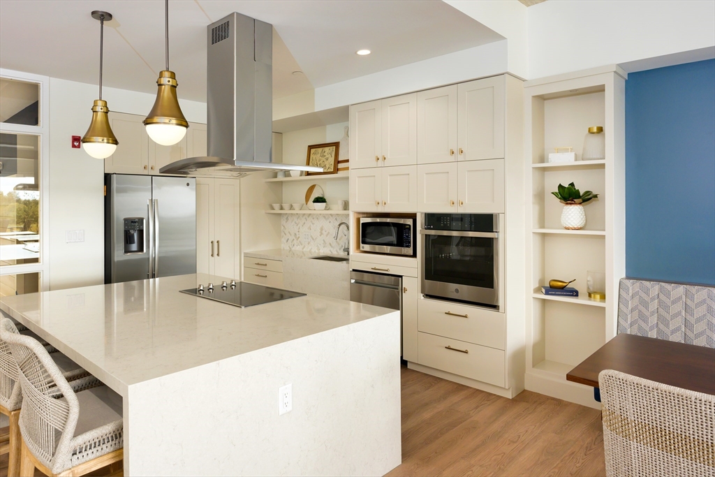 130 Chief Justice Cushing Highway, Unit 213 Scituate, MA 02066 - Photo 21 of 40 a kitchen with stainless steel appliances a stove a sink and white cabinets