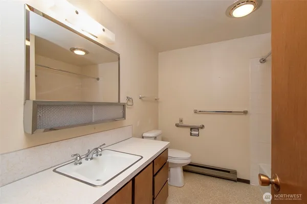 a bathroom with a sink a toilet and shower