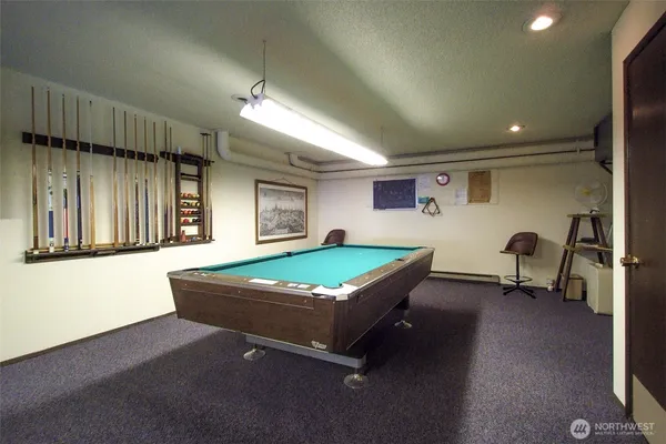 a living room with furniture pool table and a window