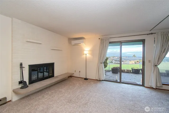 an empty room with fireplace and sliding door