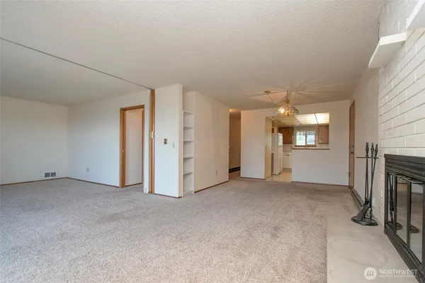 an empty room with a fireplace and a window