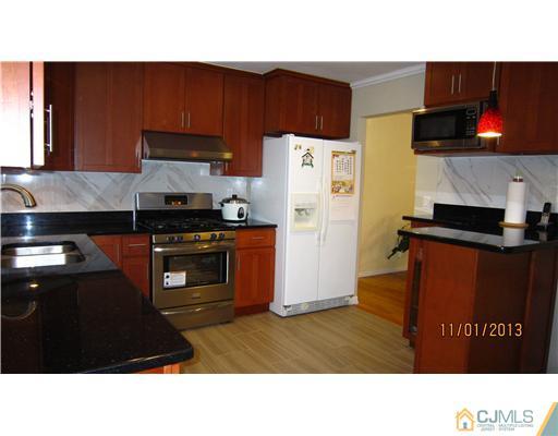 24 Roxy Avenue Edison, NJ 08820 - Photo 11 of 15 a kitchen with stainless steel appliances a stove a refrigerator and a microwave
