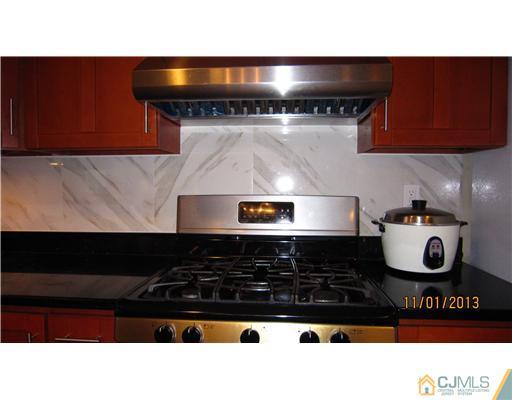 24 Roxy Avenue Edison, NJ 08820 - Photo 12 of 15 a kitchen with a stove and cabinets