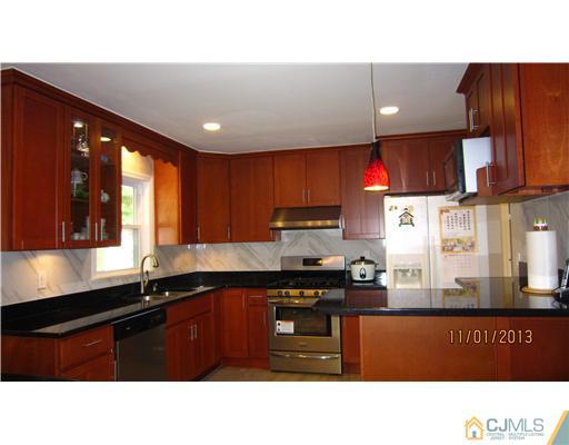 24 Roxy Avenue Edison, NJ 08820 - Photo 3 of 15 a kitchen with stainless steel appliances granite countertop a sink wooden cabinets and a granite counter tops