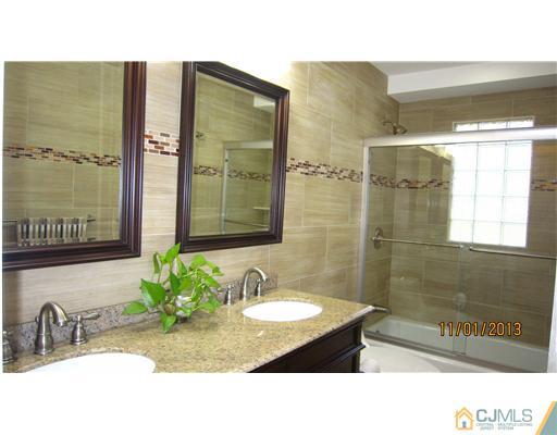 24 Roxy Avenue Edison, NJ 08820 - Photo 5 of 15 a bathroom with a sink a mirror and a shower