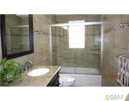 24 Roxy Avenue Edison, NJ 08820 - Photo 6 of 15 a bathroom with a sink a toilet a mirror and shower