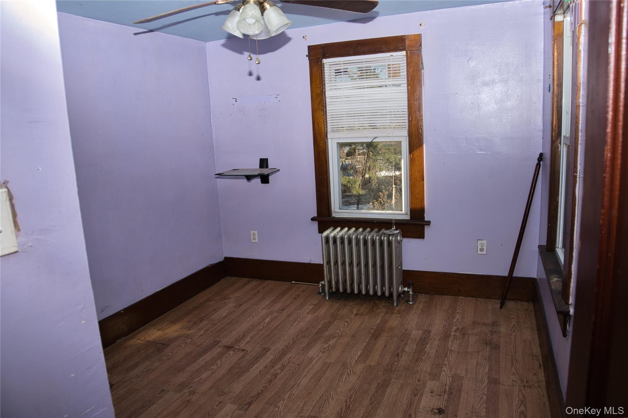 256 Round Hill Road Florida, NY 10921 - Photo 10 of 14 Spare room with radiator, dark wood finished floors, and a ceiling fan