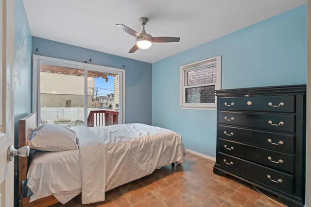 a bedroom with a bed a chandelier and a window