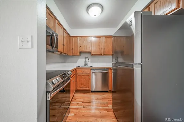 a kitchen with stainless steel appliances granite countertop a stove a sink and a refrigerator