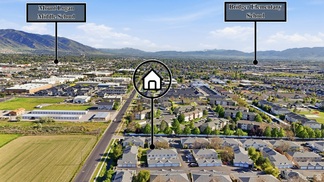 99 Penhurst Place Logan, UT 84341 - Photo 31 of 34 Aerial perspective showcasing a residential community surrounded by mountainous terrain and a distant city skyline