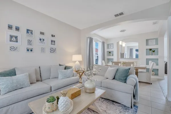 a kitchen with stainless steel appliances granite countertop a stove top oven a sink dishwasher a refrigerator and a dining table with white cabinets