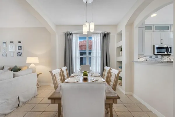 a large white kitchen with a large window appliances and cabinets