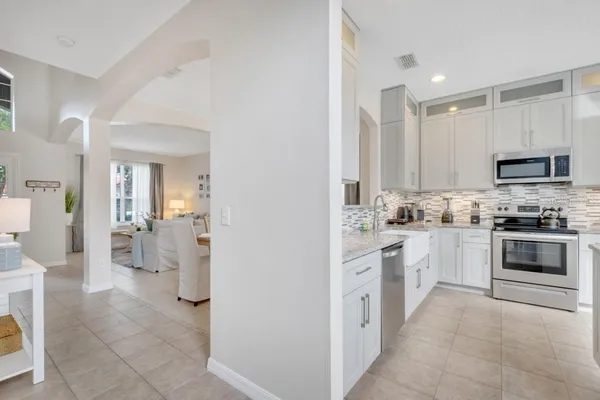 a kitchen with granite countertop white cabinets white stainless steel appliances with a sink and dishwasher