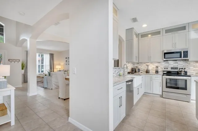 a kitchen with granite countertop white cabinets white stainless steel appliances with a sink and dishwasher