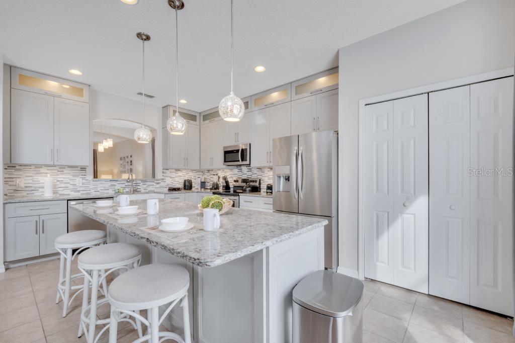 162 Cordova Avenue Davenport, FL 33897 - Photo 19 of 80 a kitchen with kitchen island granite countertop a table chairs sink and cabinets
