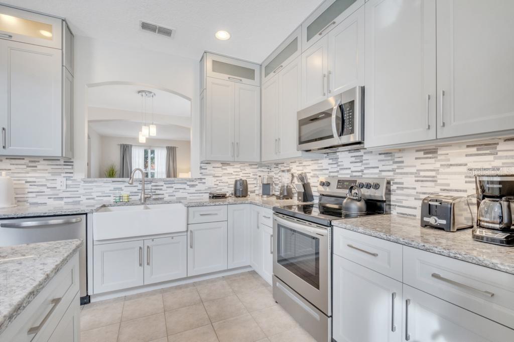 162 Cordova Avenue Davenport, FL 33897 - Photo 20 of 80 a kitchen with granite countertop white cabinets white stainless steel appliances with a sink and dishwasher