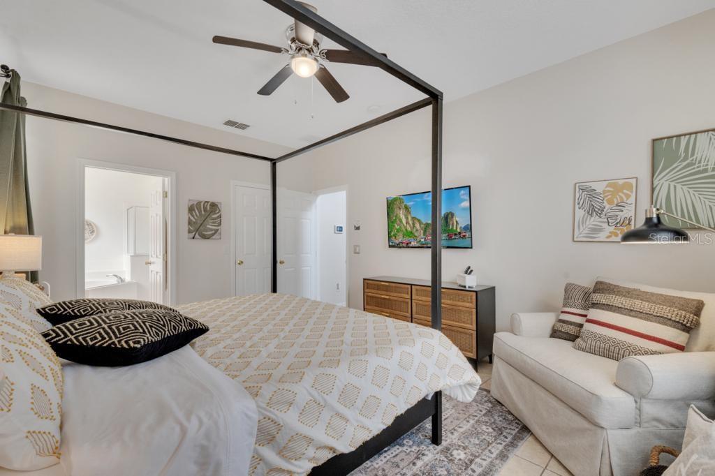 162 Cordova Avenue Davenport, FL 33897 - Photo 35 of 80 a bedroom with a bed ceiling fan and a wooden floor