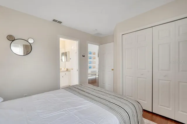 a bedroom with a bed and a painting on the wall