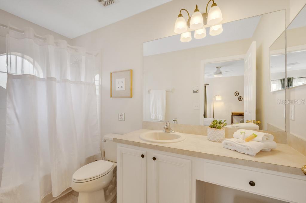 162 Cordova Avenue Davenport, FL 33897 - Photo 55 of 80 a bathroom with a granite countertop sink a toilet and a mirror