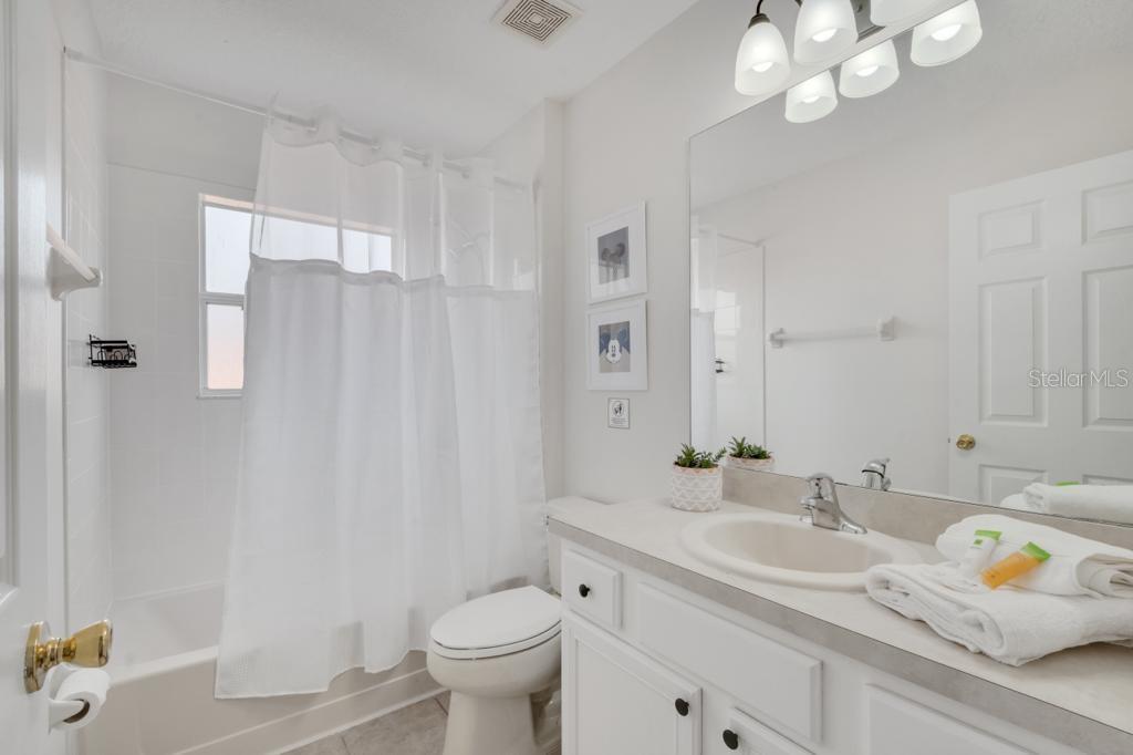 162 Cordova Avenue Davenport, FL 33897 - Photo 66 of 80 a bathroom with a sink toilet double vanity and shower