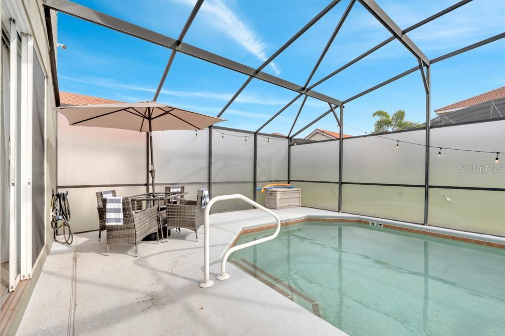 162 Cordova Avenue Davenport, FL 33897 - Photo 7 of 80 a view of a patio with a table and chairs under an umbrella