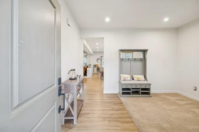 a view of a hallway with furniture and wooden floor