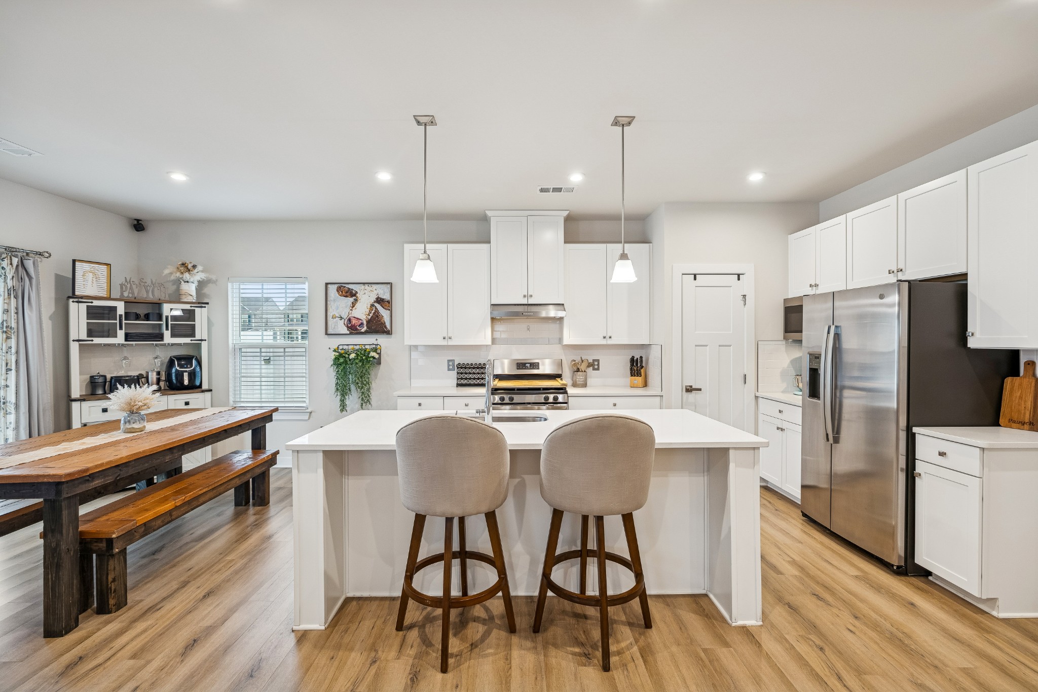 809 Mill Tree Court Smyrna, TN 37167 - Photo 7 of 42 a kitchen with stainless steel appliances kitchen island granite countertop a refrigerator a stove a sink a dining table and chairs with wooden floor