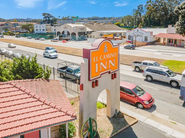 an aerial view of a swimming pool with outdoor seating and city view