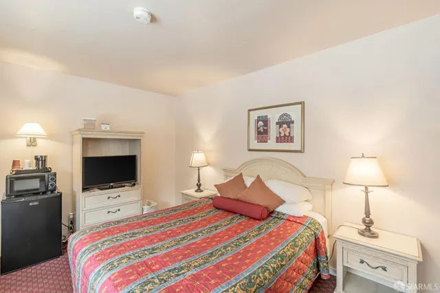 a bedroom with two beds and painting on the wall