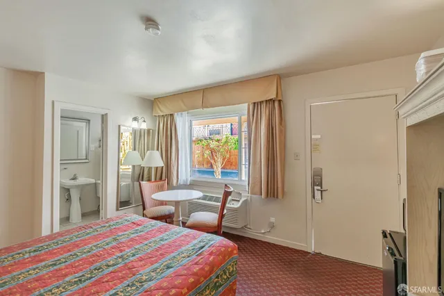 a bedroom with two beds and a chair