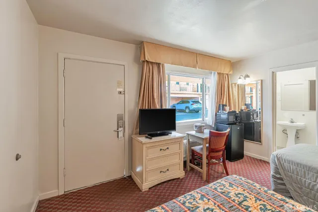 a bedroom with a bed and a flat screen tv