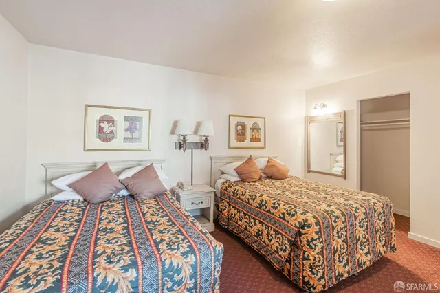 a bedroom with two beds and painting on the wall