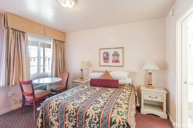 a bedroom with a bed and a painting on the wall