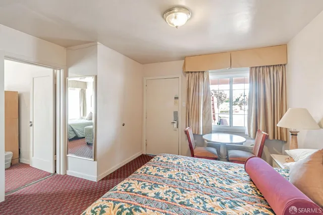 a bedroom with a bed flat screen tv and a large window