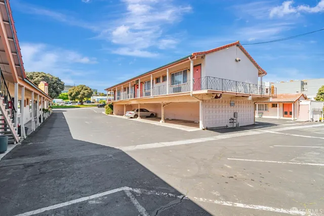 a view of a house with a wooden deck and furniture