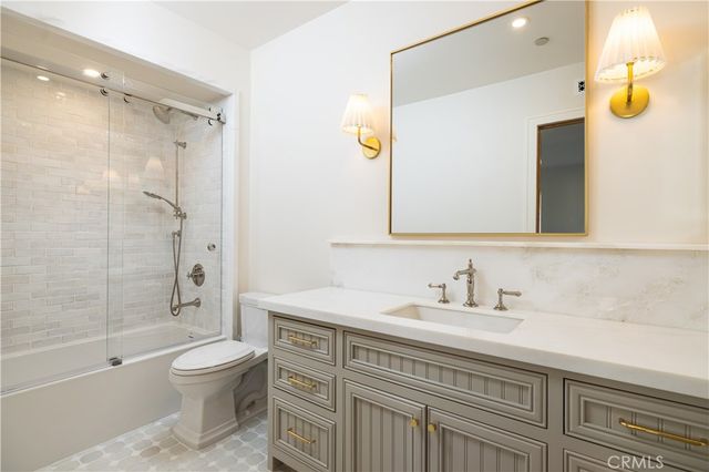 a living room with furniture a flat screen tv and kitchen view