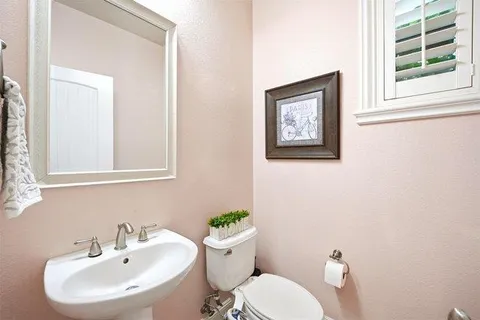 a bathroom with a toilet a sink and a mirror