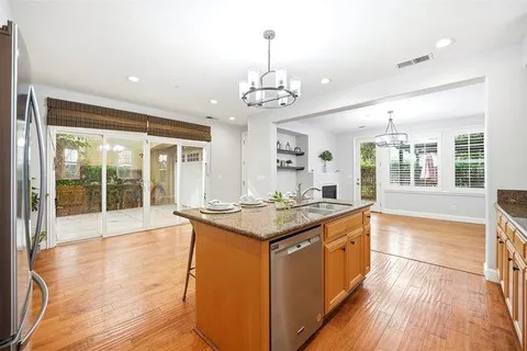 a kitchen with stainless steel appliances granite countertop a stove and wooden floor