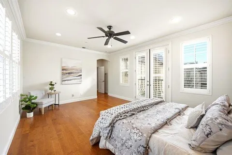 a bedroom with a large bed chandelier and a window
