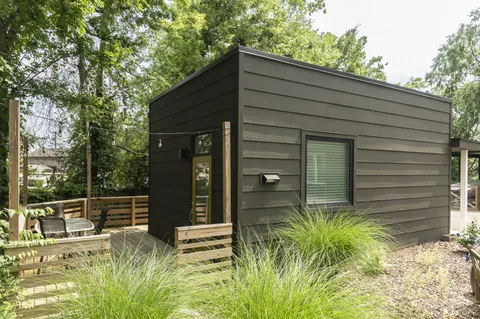 a view of house with backyard and outdoor seating