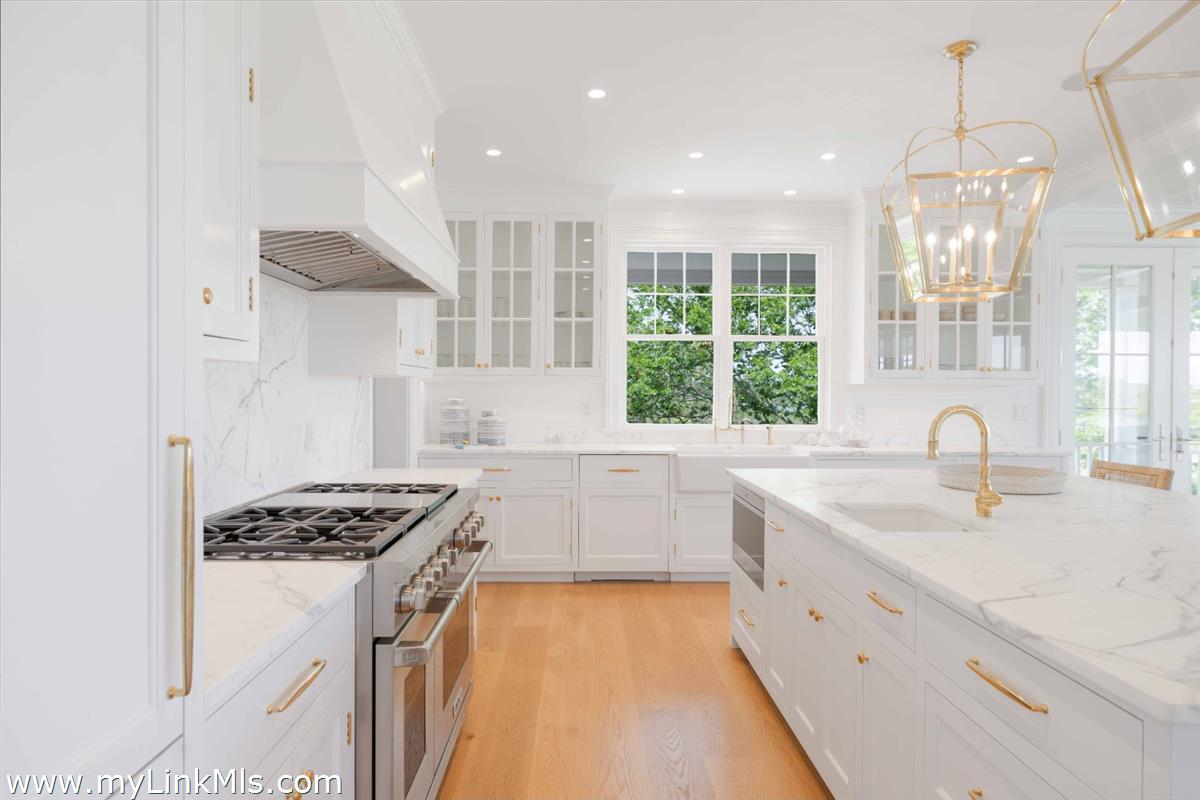 256 Polpis Road Nantucket, MA 02554 - Photo 8 of 30 a kitchen that has a sink a stove and a wooden floor